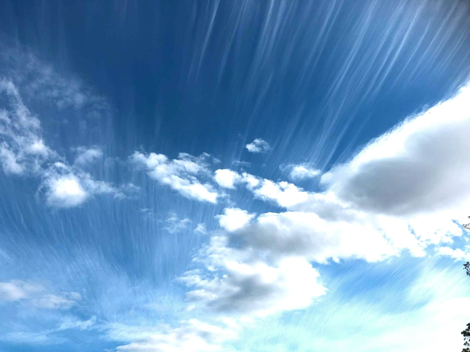 A wide open blue sky with soft clouds