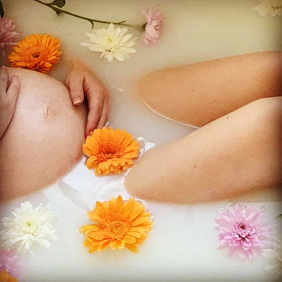 Expectant mother relaxing in a warm flower bath