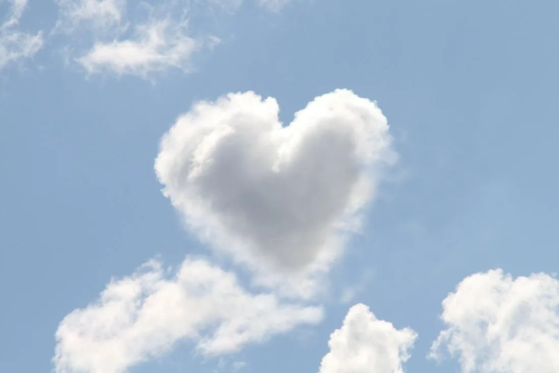 A heart-shaped cloud in a blue sky