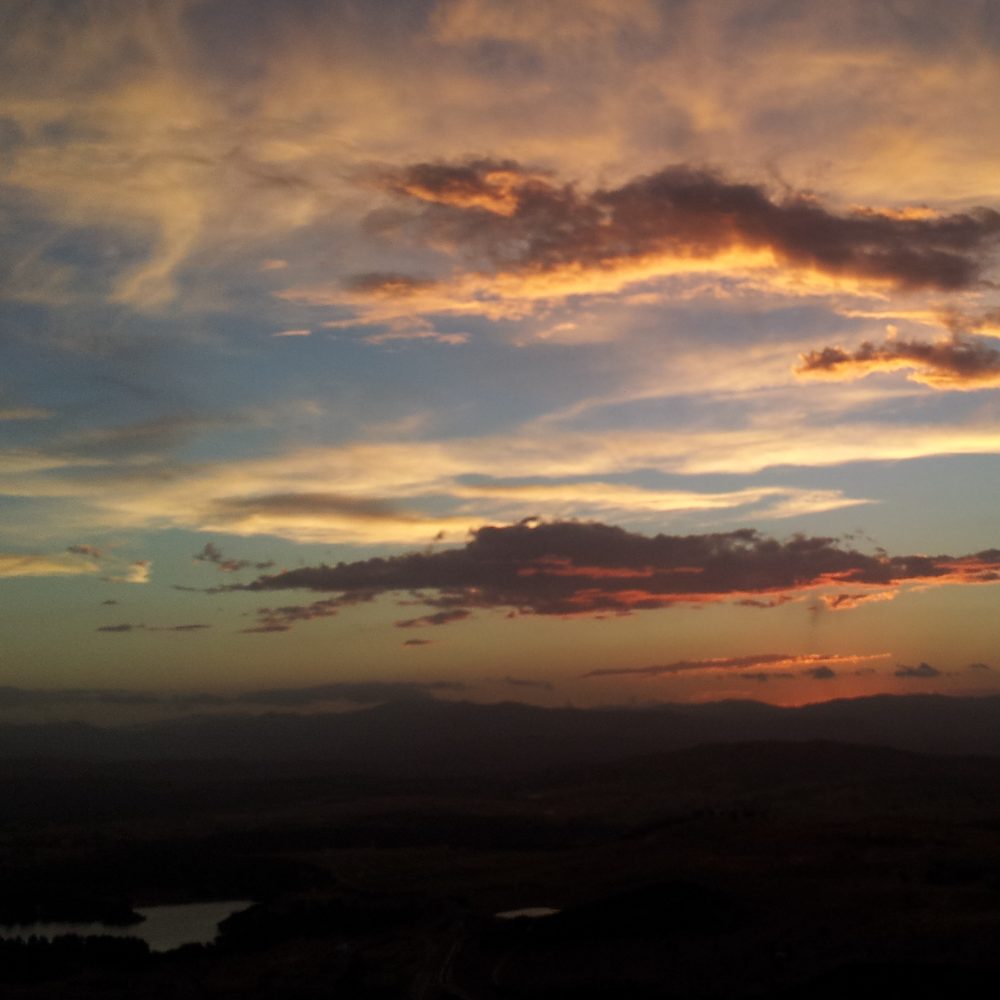 A dramatic sunset over hills — a moment of stillness and remembrance