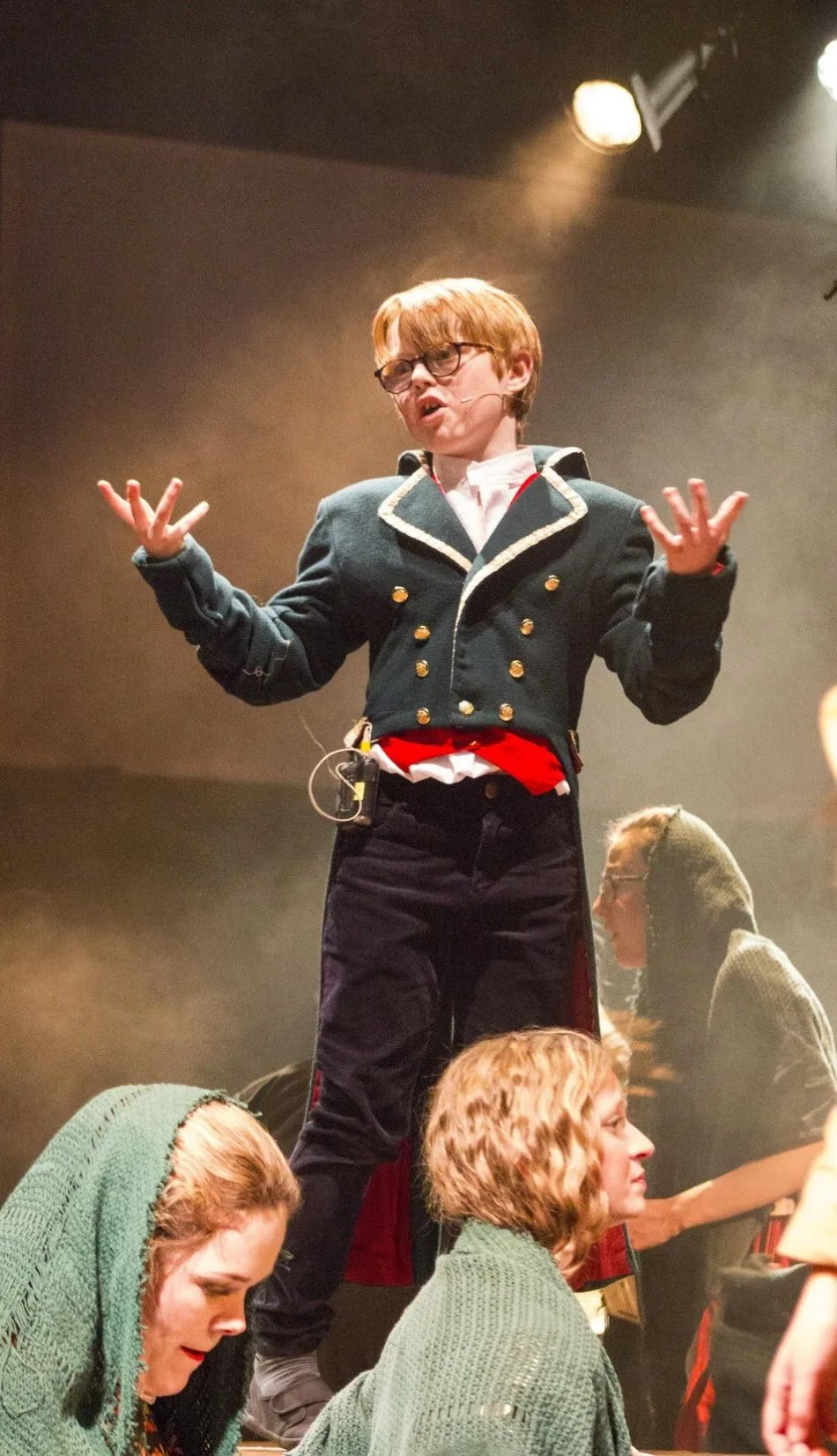 A young performer acting on stage in a theatre production